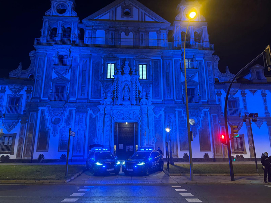 Edificio histórico iluminado con el color azul de la Policía Nacional.
